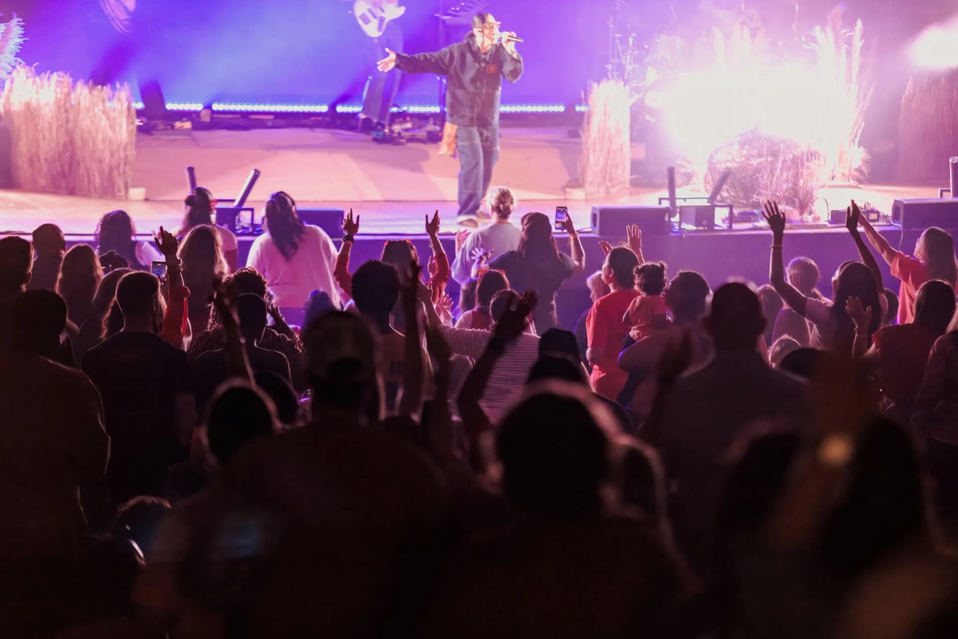 Crowd with hands raised toward Lizzie Morgan on a pink-lit stage at Santander Performing Arts Center